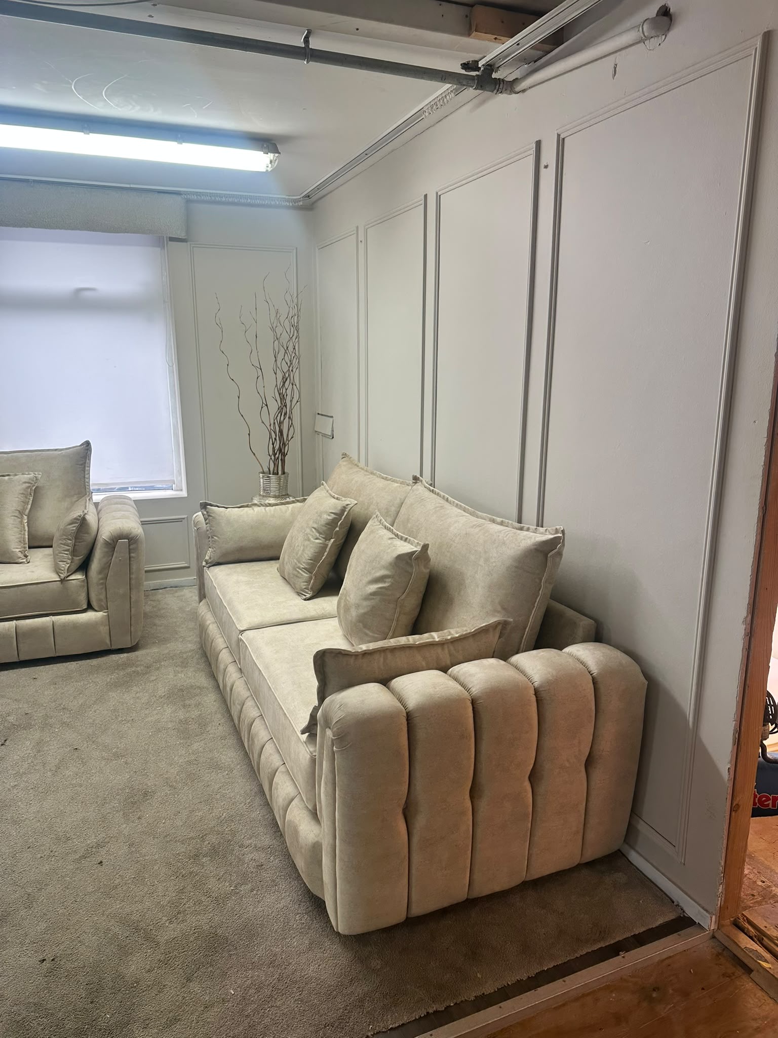 Light upholstered seating with vertical channel detailing on the arms.
