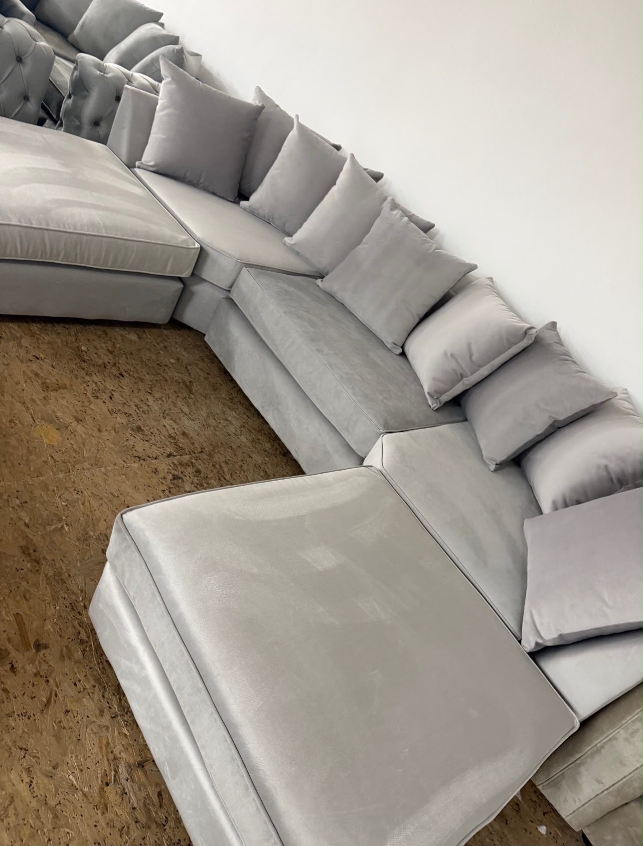 Light U-shaped sofa with wide open ends and loose back cushions.