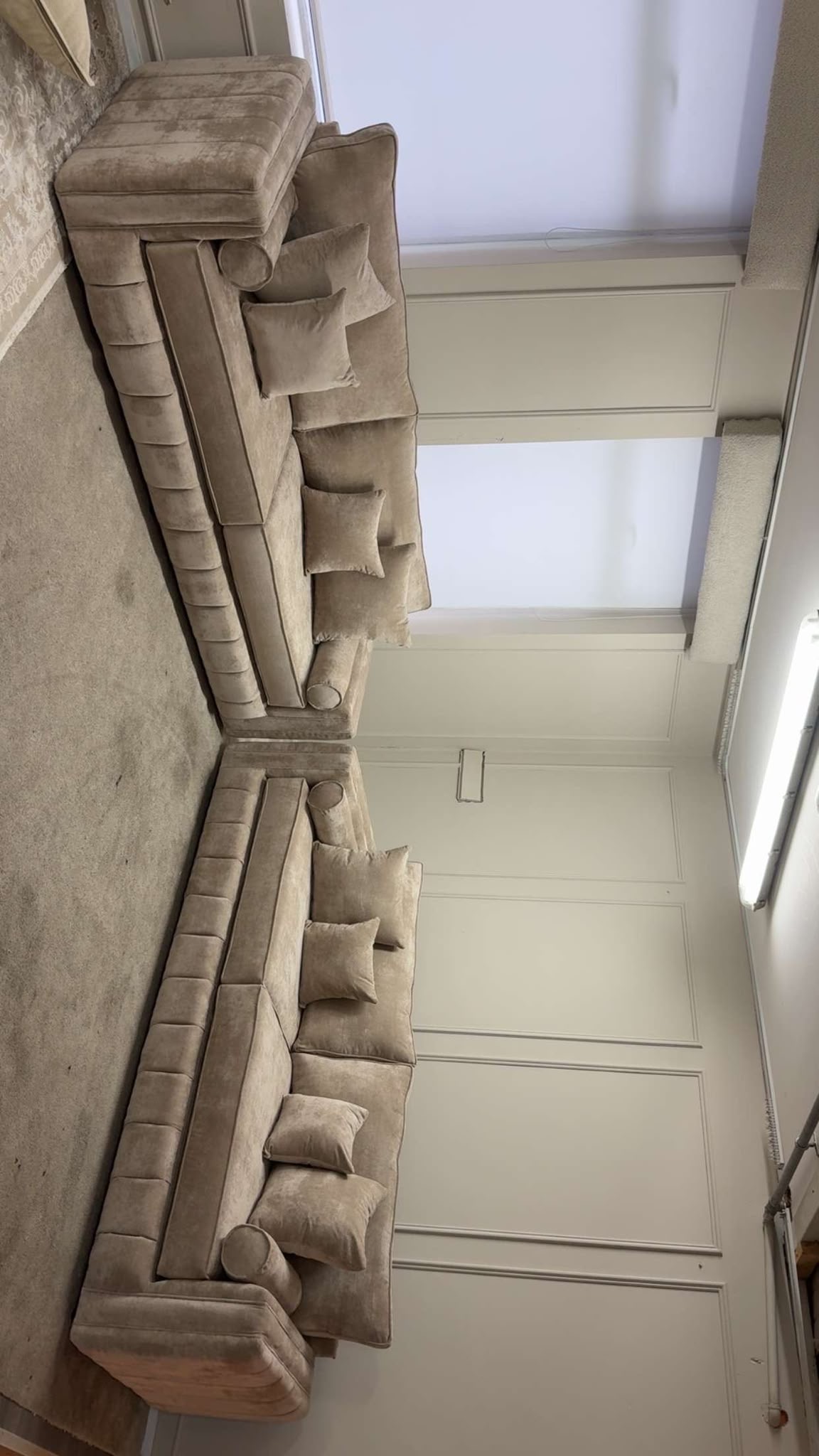 Neutral U-shaped sofa photographed across a room.