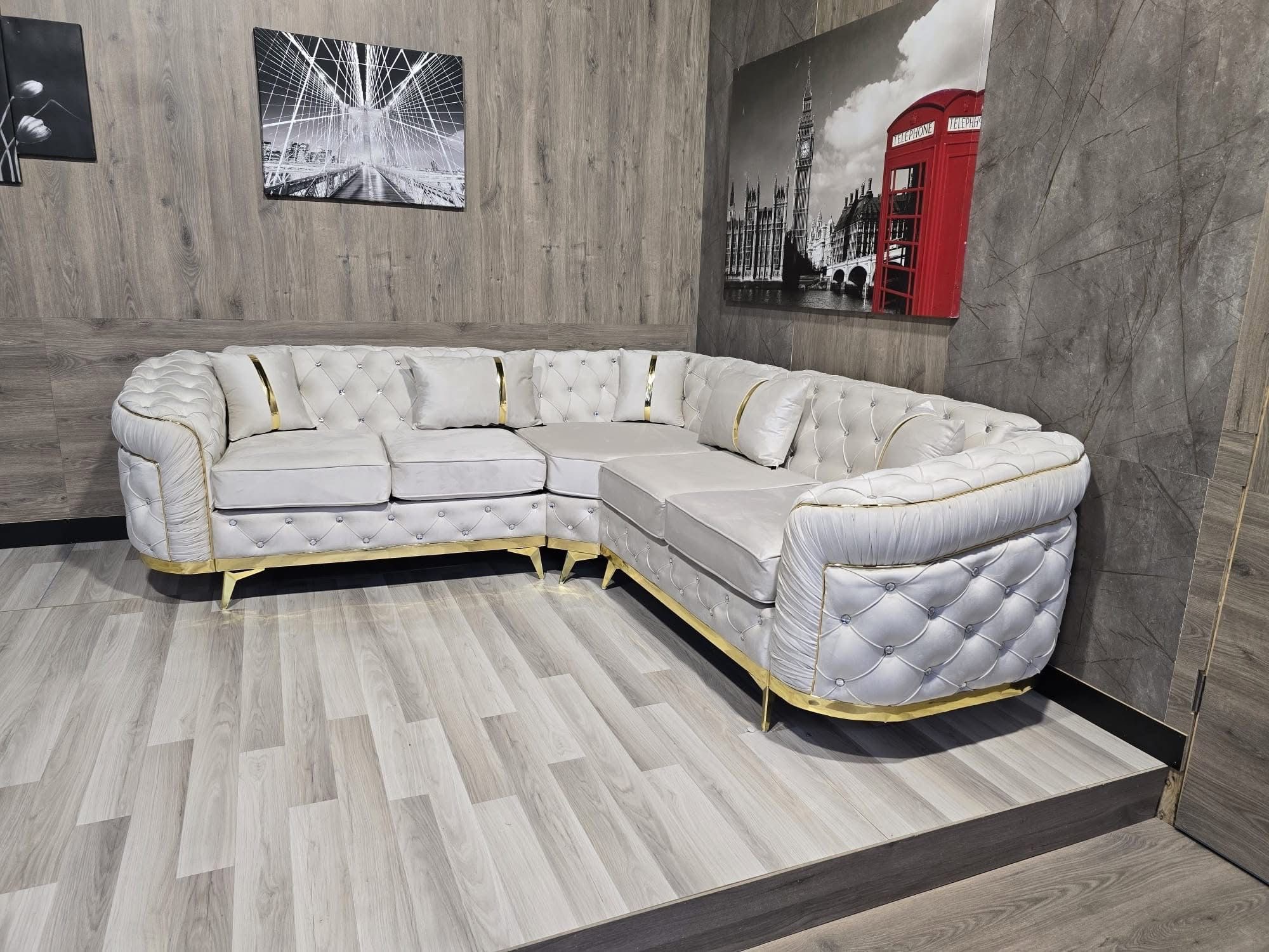 Light corner sofa with button detailing and a gold-tone base.