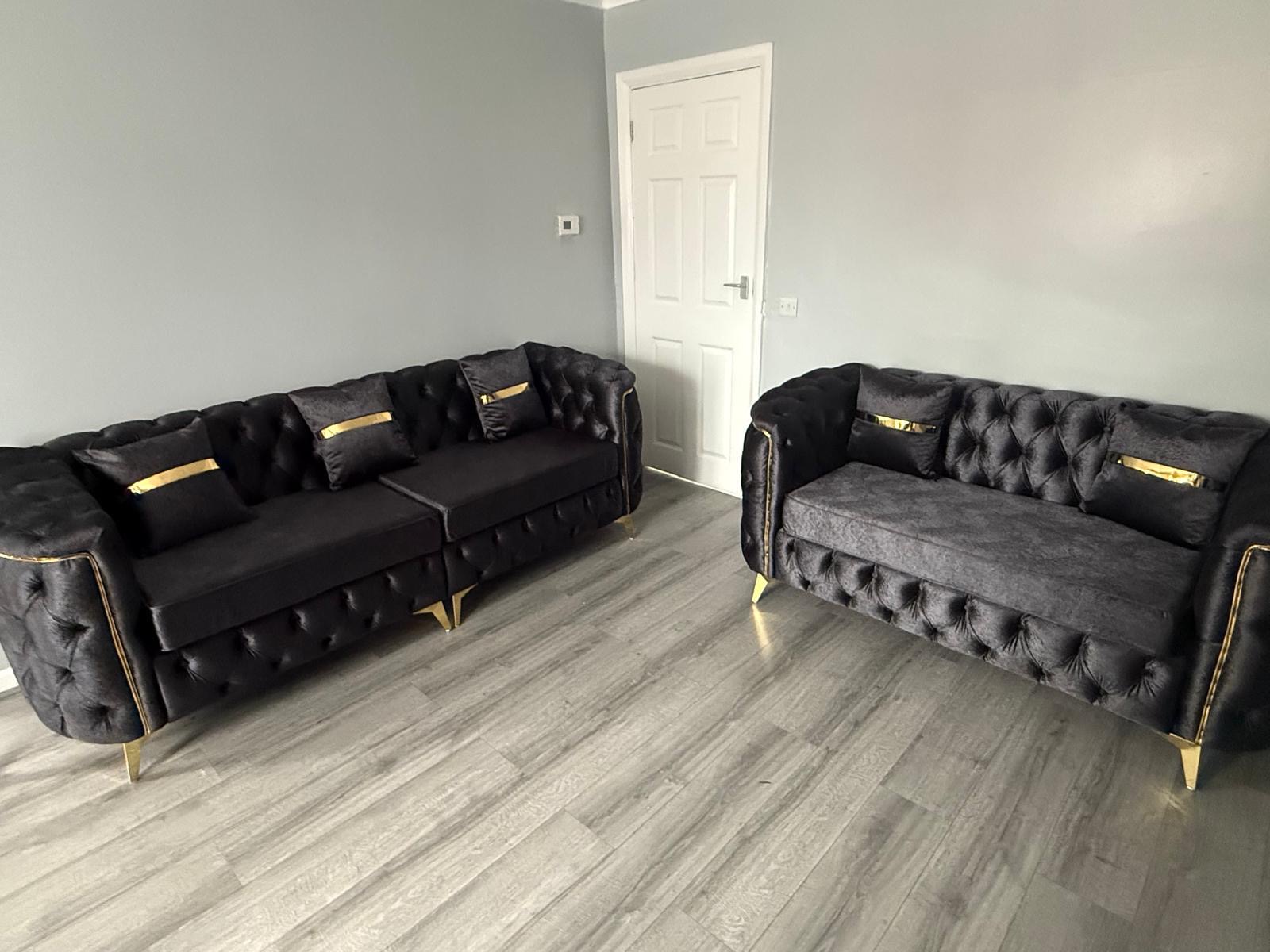 Dark sofa set with button detailing and gold-tone feet.