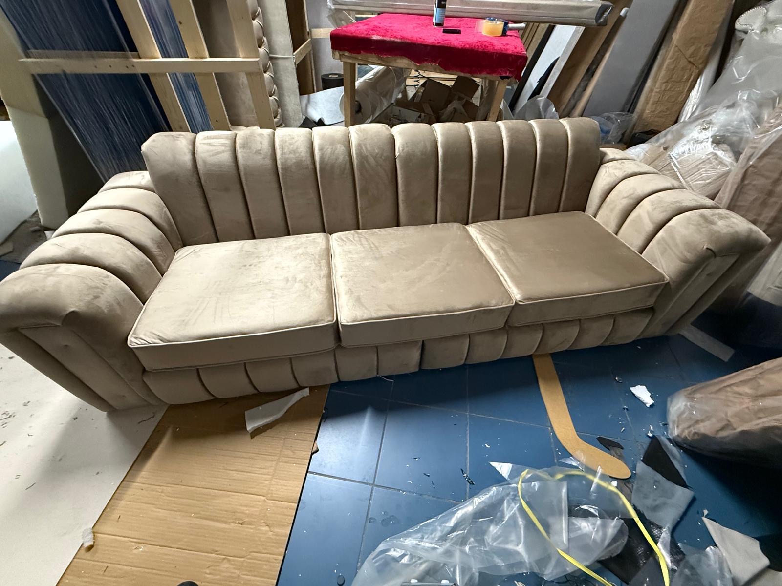 Neutral sofa with rounded arms and a vertically padded back.