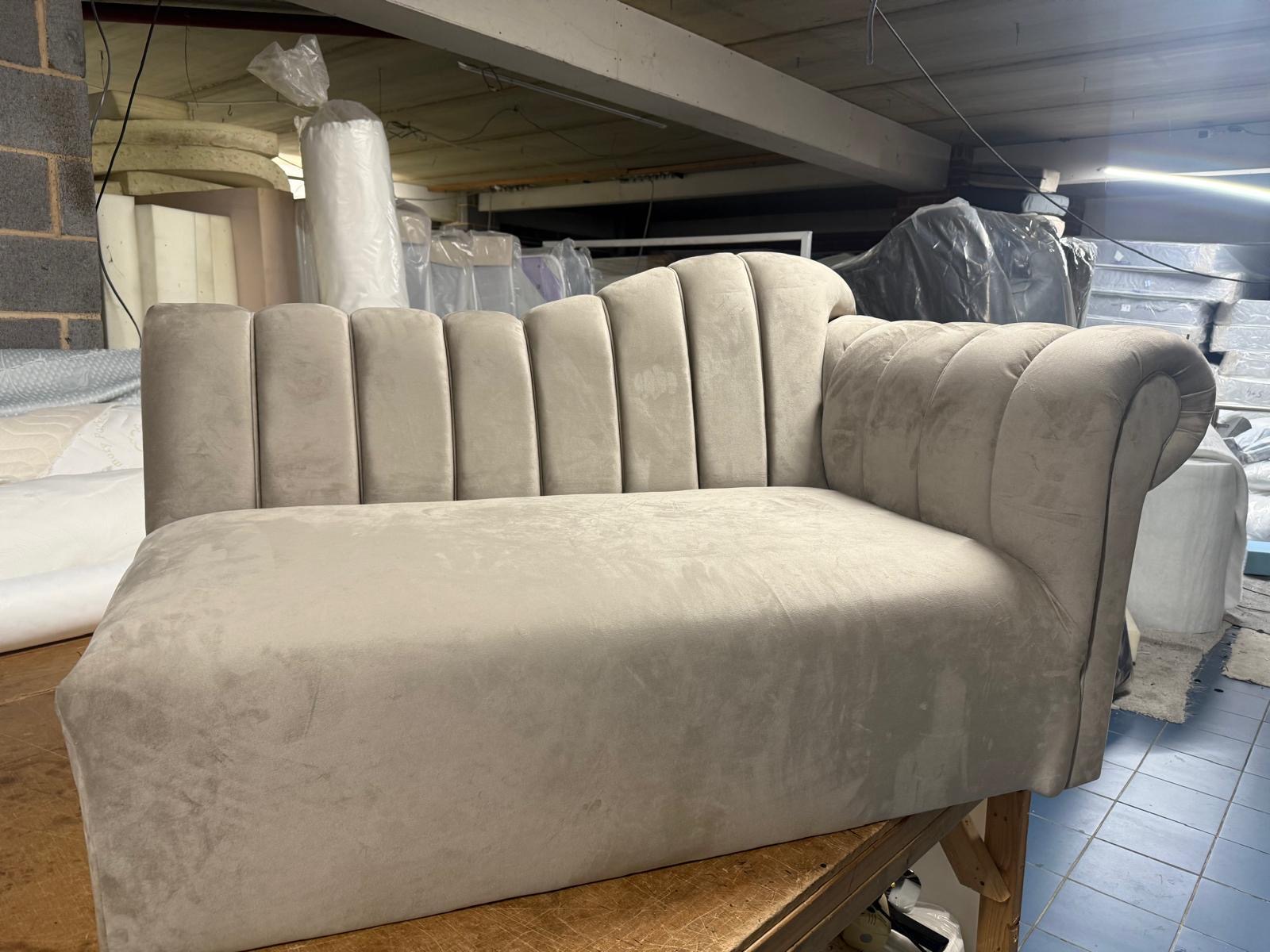 Neutral sofa with a tall padded back and flared arms.