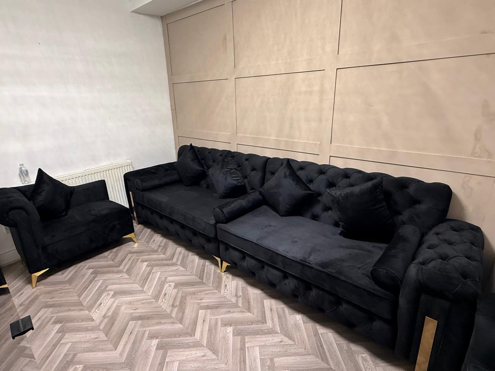 Dark button-tufted sofa set in a living room.