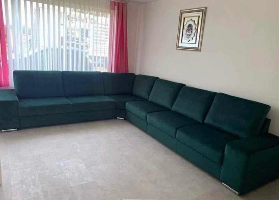 Dark teal corner sofa with broad arms.