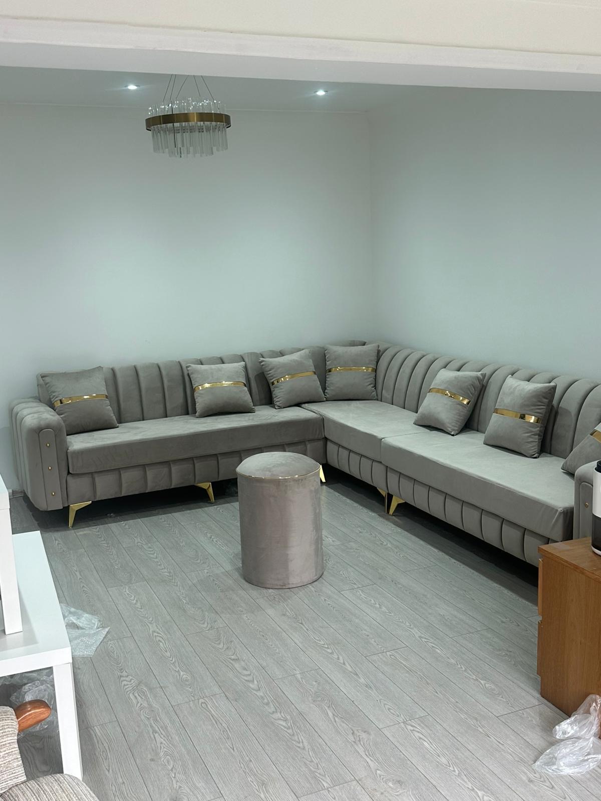 Light corner sofa with vertical channel detailing on its arms.