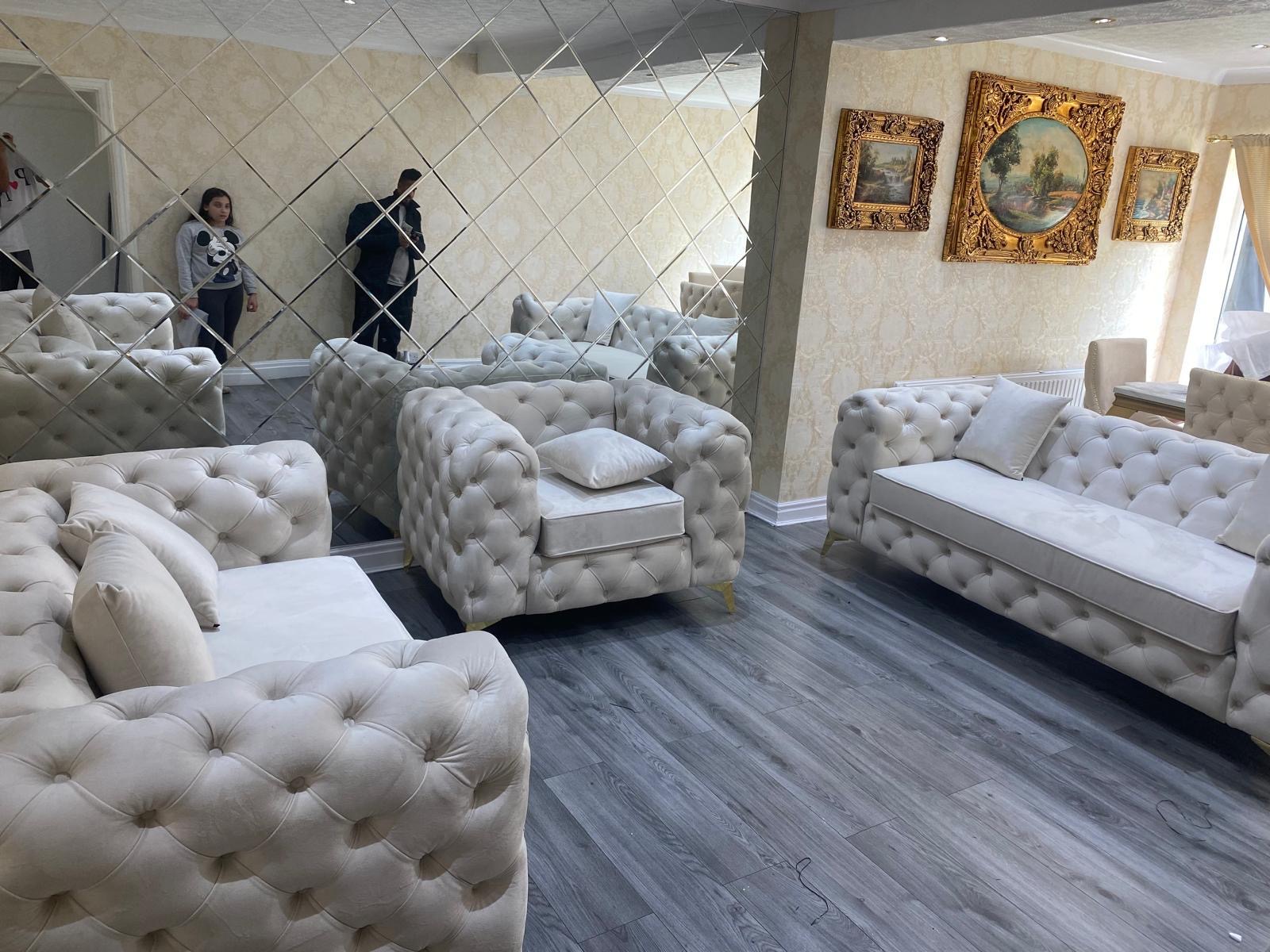 Light button-tufted sofa and armchair collection in a showroom.