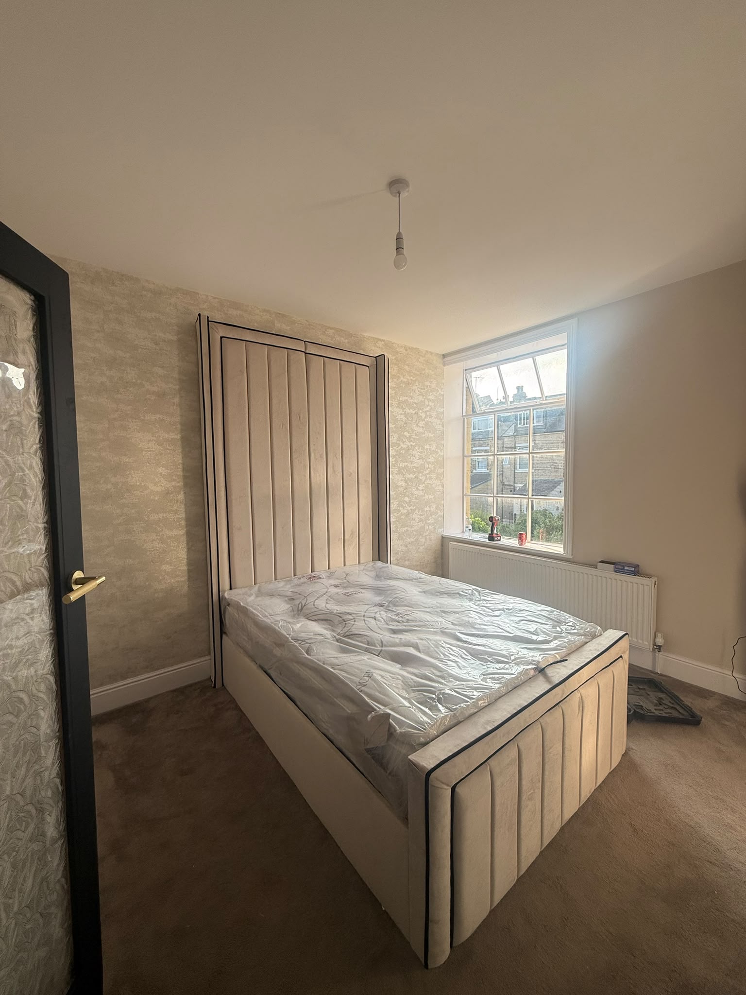 Neutral upholstered bed with vertical panel detailing.