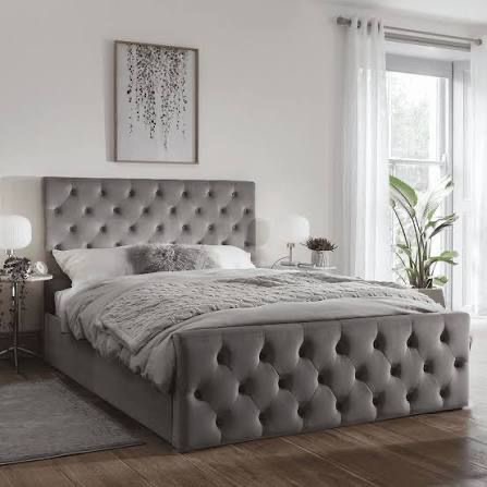 Grey upholstered bed with deep button-tufted detailing.