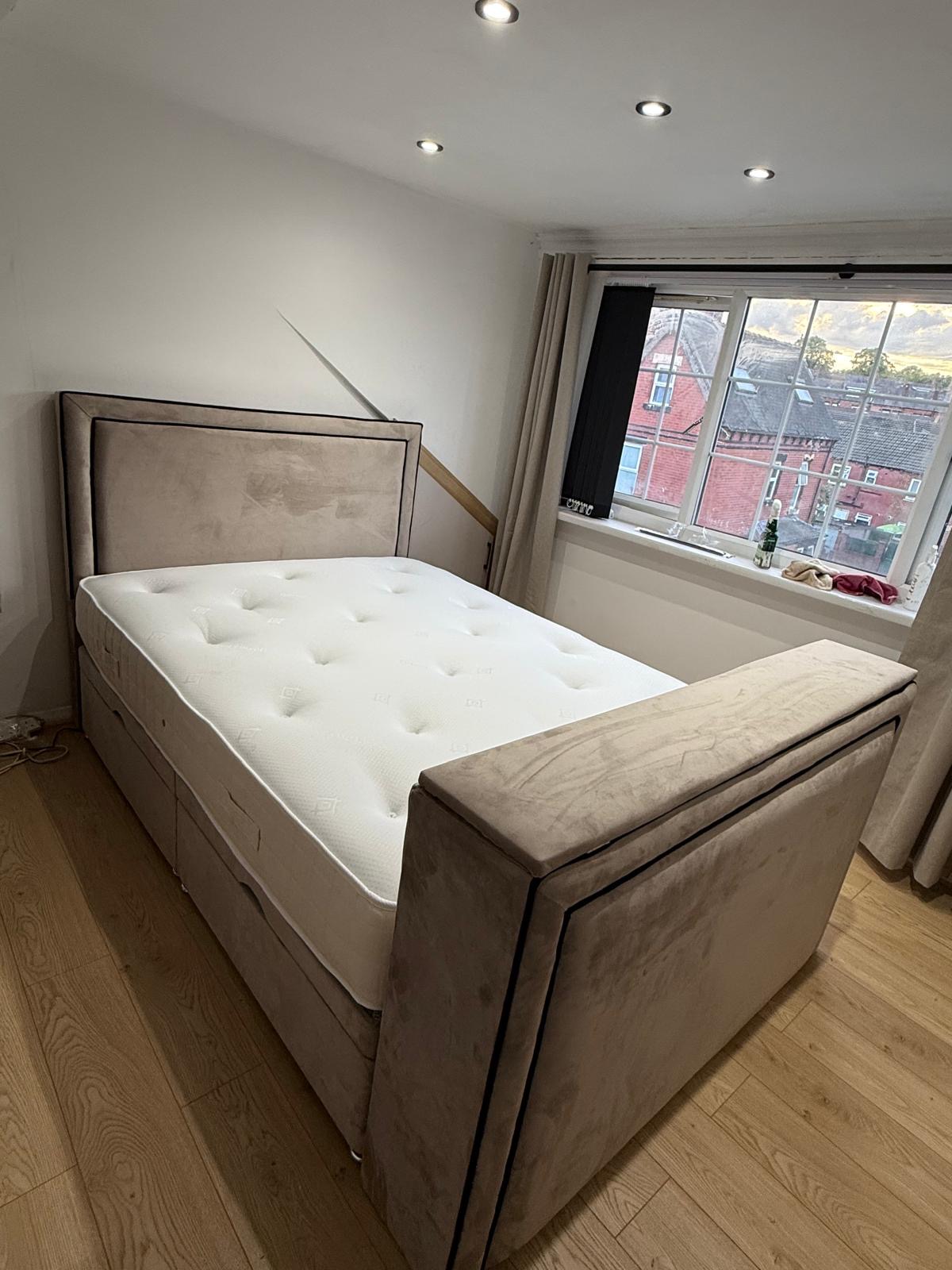 Neutral upholstered bed with bordered panels.