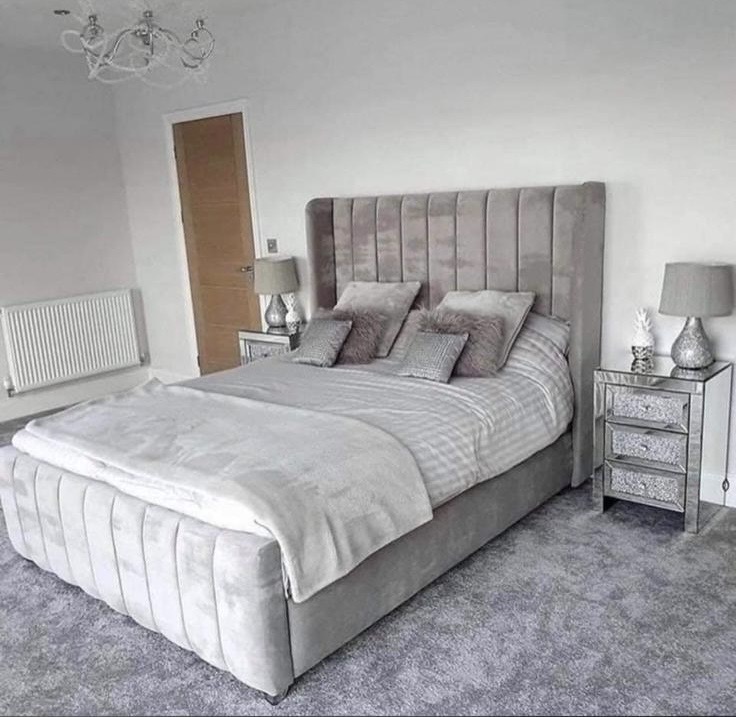 Silver-grey upholstered bed with vertical padded detailing.